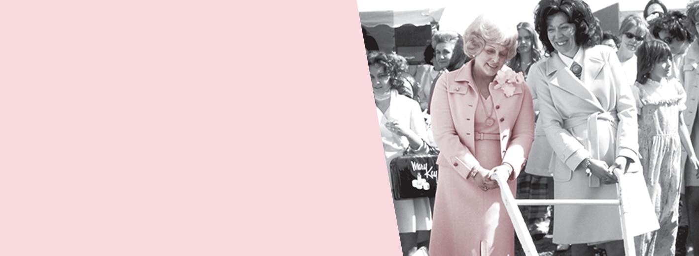 Mary Kay Ash poses for a picture alongside another woman at an outdoor event.