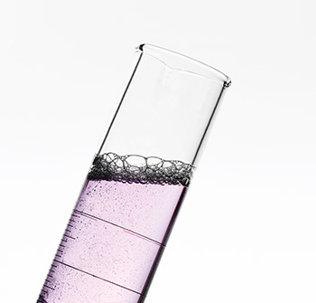 A graduated cylinder partially filled with pink liquid