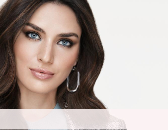 A smiling woman is wearing a Mary Kay makeup artist look that incorporates a hint of color and metallic neutrals to make skin appear sun-kissed for summer. 