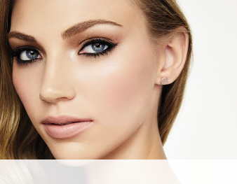 A smiling woman is wearing a Mary Kay makeup artist look that incorporates a hint of color and metallic neutrals to make skin appear sun-kissed for summer. 